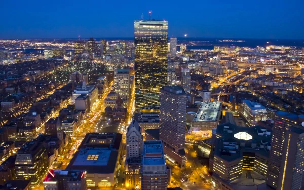 A stunning HD wallpaper showcasing Boston's skyline at dusk, highlighting the illuminated buildings and bustling streets in a vibrant cityscape.