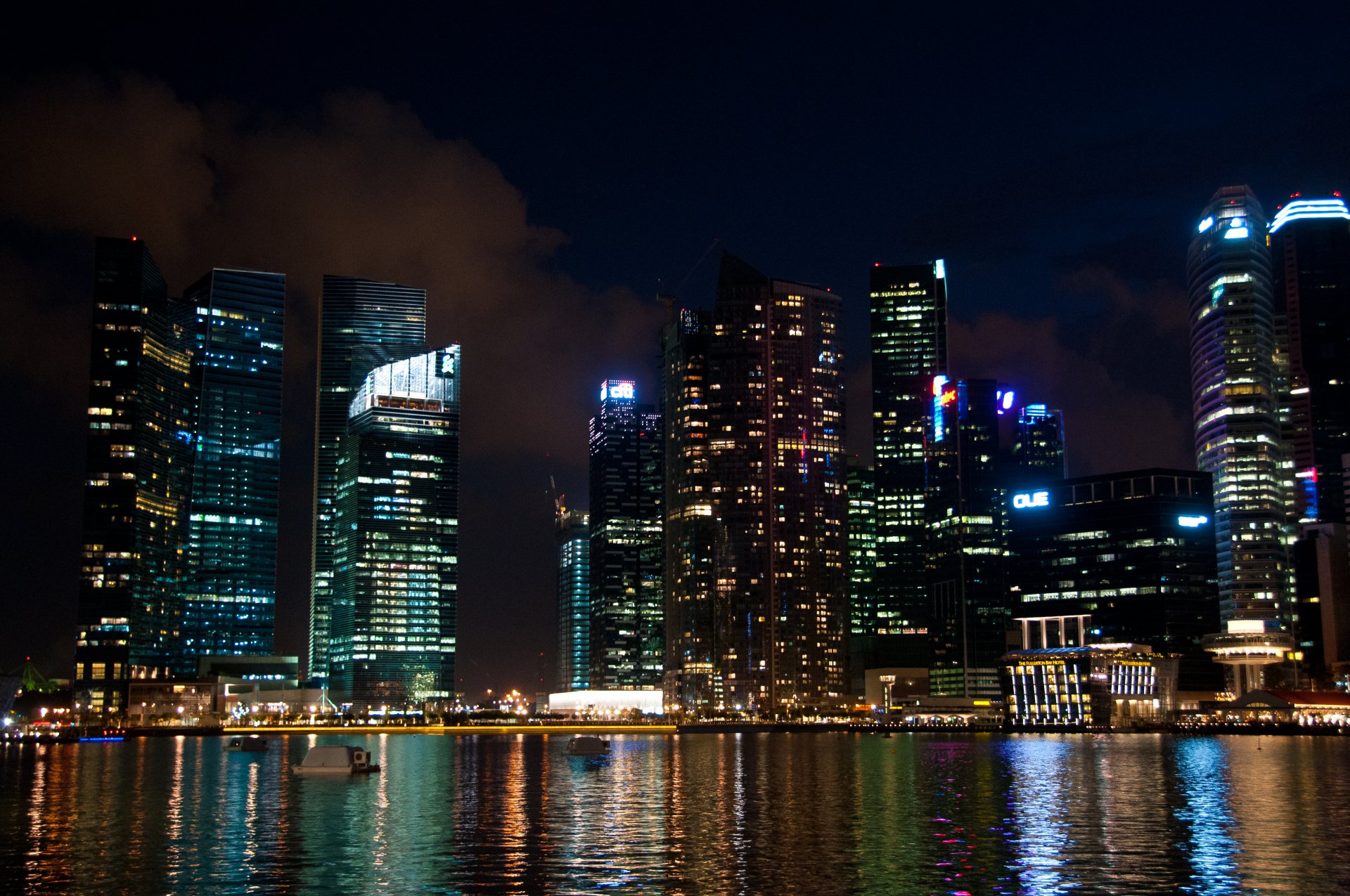4K Ultra HD wallpaper of Singapore’s man-made skyline at night, featuring illuminated skyscrapers reflecting on the water.