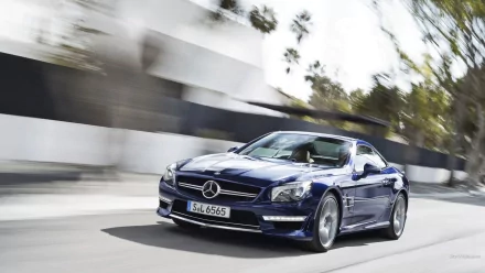 HD PC desktop wallpaper background showing a blue Mercedes-Benz SL65 speeding along a sunlit urban road, a sleek coupe captured in motion with blurred surroundings.