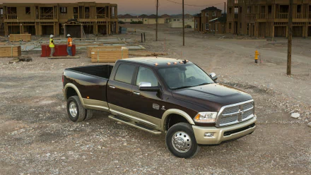 HD PC desktop wallpaper showing a Dodge Ram 3500 pickup parked on a dusty construction site with unfinished houses in the background.