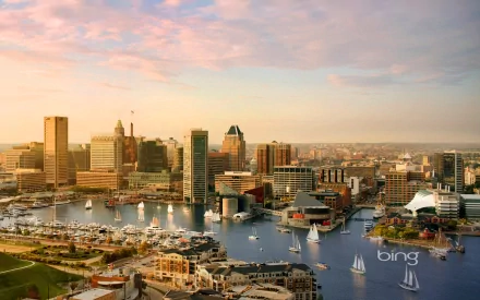 HD desktop wallpaper showcasing Baltimore’s harbor with boats, ships, and city buildings under a pastel sky at sunset.