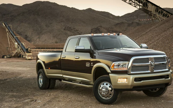 HD desktop wallpaper featuring a Dodge Ram 3500 truck parked at a construction site with mountains in the background.