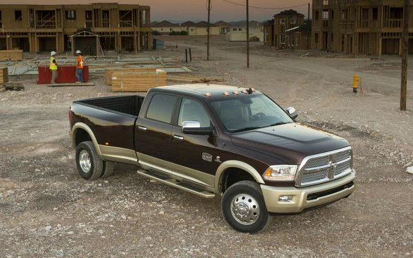 HD PC desktop wallpaper showing a Dodge Ram 3500 pickup parked on a dusty construction site with unfinished houses in the background.