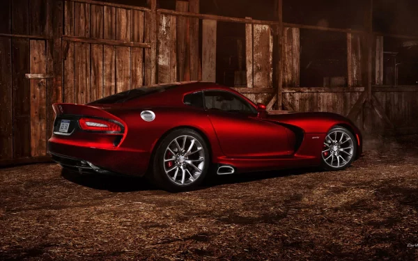 HD desktop wallpaper featuring a sleek red Dodge Viper sports car parked in a rustic, dimly lit setting.