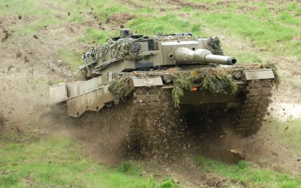 HD desktop wallpaper featuring a Leopard 2 military tank moving through muddy terrain, showcasing its tracked design and camouflage in action.