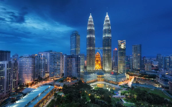 Stunning view of the Petronas Towers in Kuala Lumpur, Malaysia, illuminated against a twilight sky, showcasing the iconic skyline of this man-made architectural marvel.