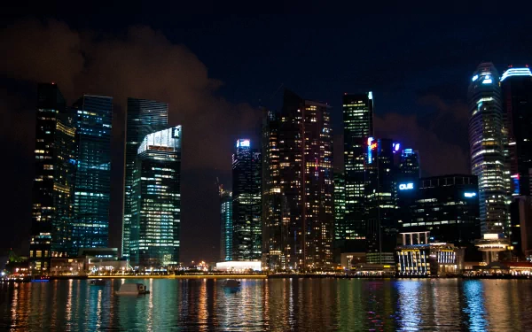 4K Ultra HD wallpaper of Singapore’s man-made skyline at night, featuring illuminated skyscrapers reflecting on the water.