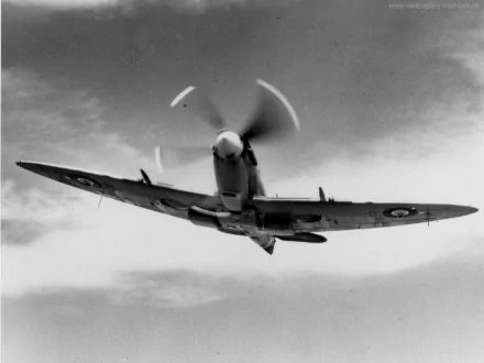 A Supermarine Spitfire in flight, showcasing its iconic shape and rotating propeller against a dramatic sky. This HD image serves as a striking military-themed desktop wallpaper.