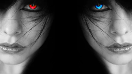 HD desktop wallpaper featuring a dark-themed close-up of a woman's face with contrasting red and blue eyes, split symmetrically against a black background.