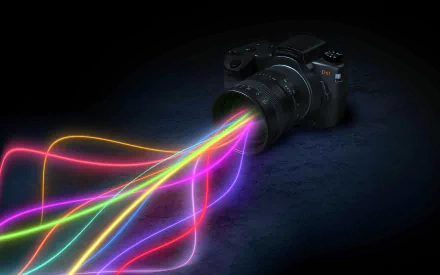 A vibrant HD desktop wallpaper featuring a camera with colorful light streaks emanating from its lens, blending technology and artistry.