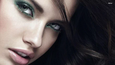 Close-up of a stunning Adriana Lima, featuring dramatic green eye makeup and cascading dark hair. This image serves as a high-definition desktop wallpaper.
