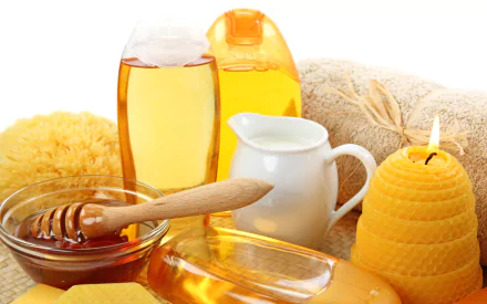 Man-made spa essentials including honey, oil bottles, a small pitcher, a yellow candle, and a sponge arranged as an HD PC desktop wallpaper and background.