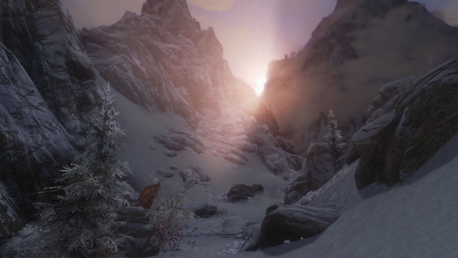 A stunning HD desktop wallpaper from The Elder Scrolls V: Skyrim, showcasing a serene snowy landscape with majestic mountains and a glowing sun emerging in the background.