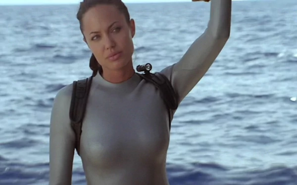 Lara Croft: Tomb Raider movie 2K Quad HD PC desktop wallpaper and background — Lara Croft in a silver wetsuit with a backpack, standing at sea.