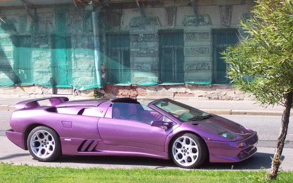 HD wallpaper of a purple Lamborghini Diablo parked beside a street, with a green-tinted glass building and a small tree in the background.