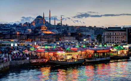 A vibrant view of Istanbul's Süleymaniye Mosque at dusk, with illuminated food stalls along the waterfront, reflecting the city's rich culture and religious heritage.