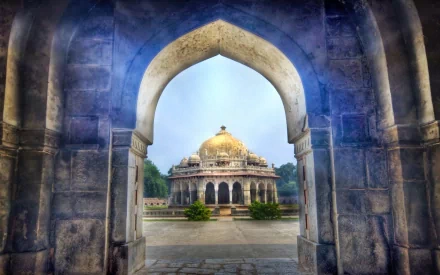 HD PC desktop wallpaper featuring a religious view of Akshardham through an ancient stone archway with intricate architectural details.
