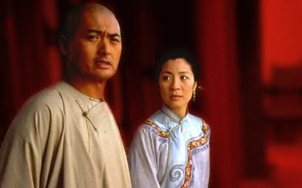 HD desktop wallpaper from the movie Crouching Tiger, Hidden Dragon: two period-costumed characters in a contemplative pose against a red architectural backdrop.