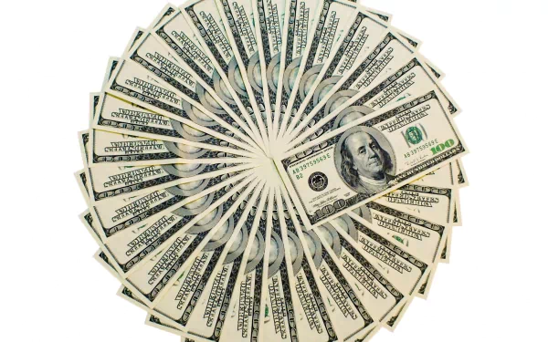 HD desktop wallpaper featuring a man-made spiral arrangement of US hundred-dollar bills on a white background.