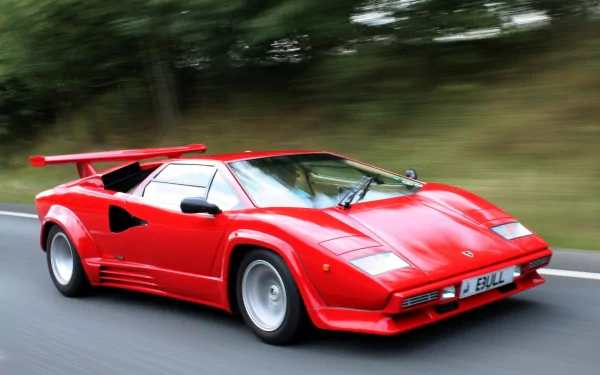 Red Lamborghini Countach speeding on a road, captured in high definition for a dynamic PC desktop wallpaper background.