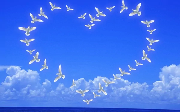 A serene HD wallpaper featuring a flock of white doves forming a heart shape against a clear blue sky with fluffy white clouds, evoking a sense of peace and tranquility.