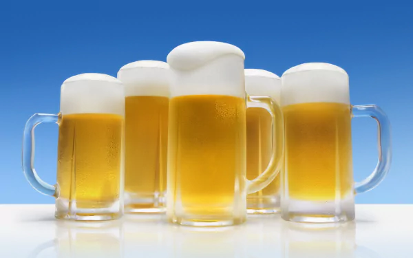 A vibrant HD desktop wallpaper featuring five frosty beer mugs filled with golden beer and topped with frothy foam, set against a clear blue background.