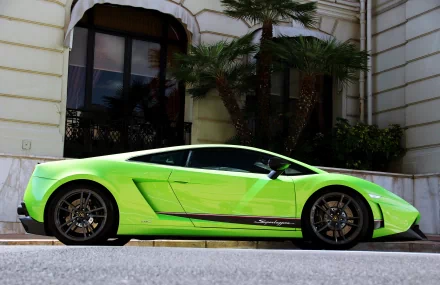 HD desktop wallpaper of a Lamborghini Gallardo Superleggera in vibrant green, parked in front of a building with palm trees.