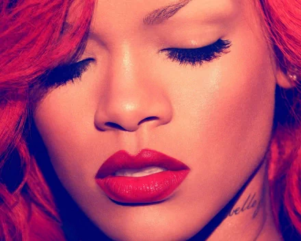 HD desktop wallpaper featuring a close-up portrait of Rihanna with vibrant red hair and lipstick, exuding a musical ambiance.