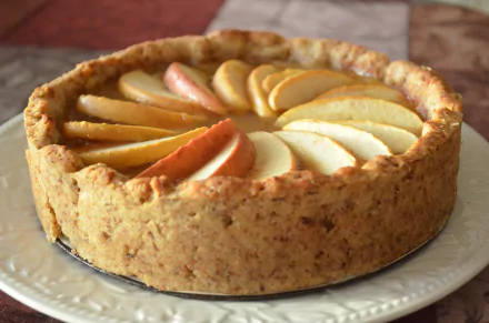A beautifully arranged apple pie with a golden crust, displayed on an elegant plate, captured as a 4K Ultra HD desktop wallpaper and background.