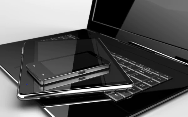 A sleek HD desktop wallpaper featuring a modern laptop, tablet, and smartphone stacked together, showcasing the seamless integration of technology.