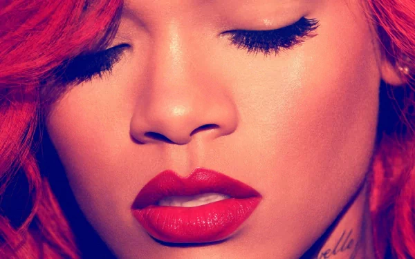 HD desktop wallpaper featuring a close-up portrait of Rihanna with vibrant red hair and lipstick, exuding a musical ambiance.
