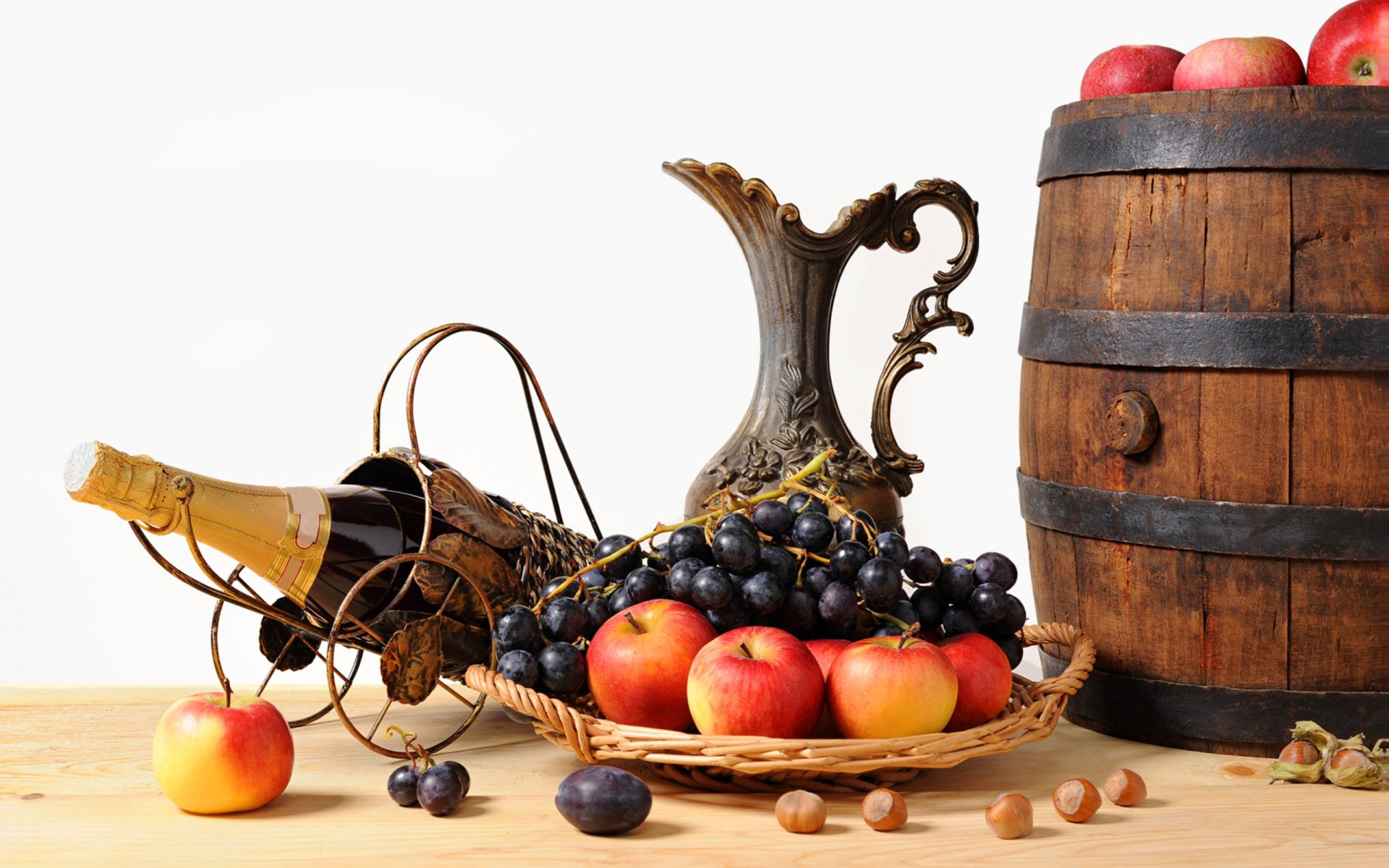 A still life composition featuring a basket of apples, grapes, and a vintage pitcher, alongside a wooden barrel, creating an inviting food-themed desktop wallpaper.