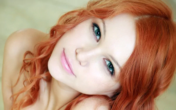 Close-up of a woman with red hair and striking eyes, perfect as a high-definition desktop wallpaper.