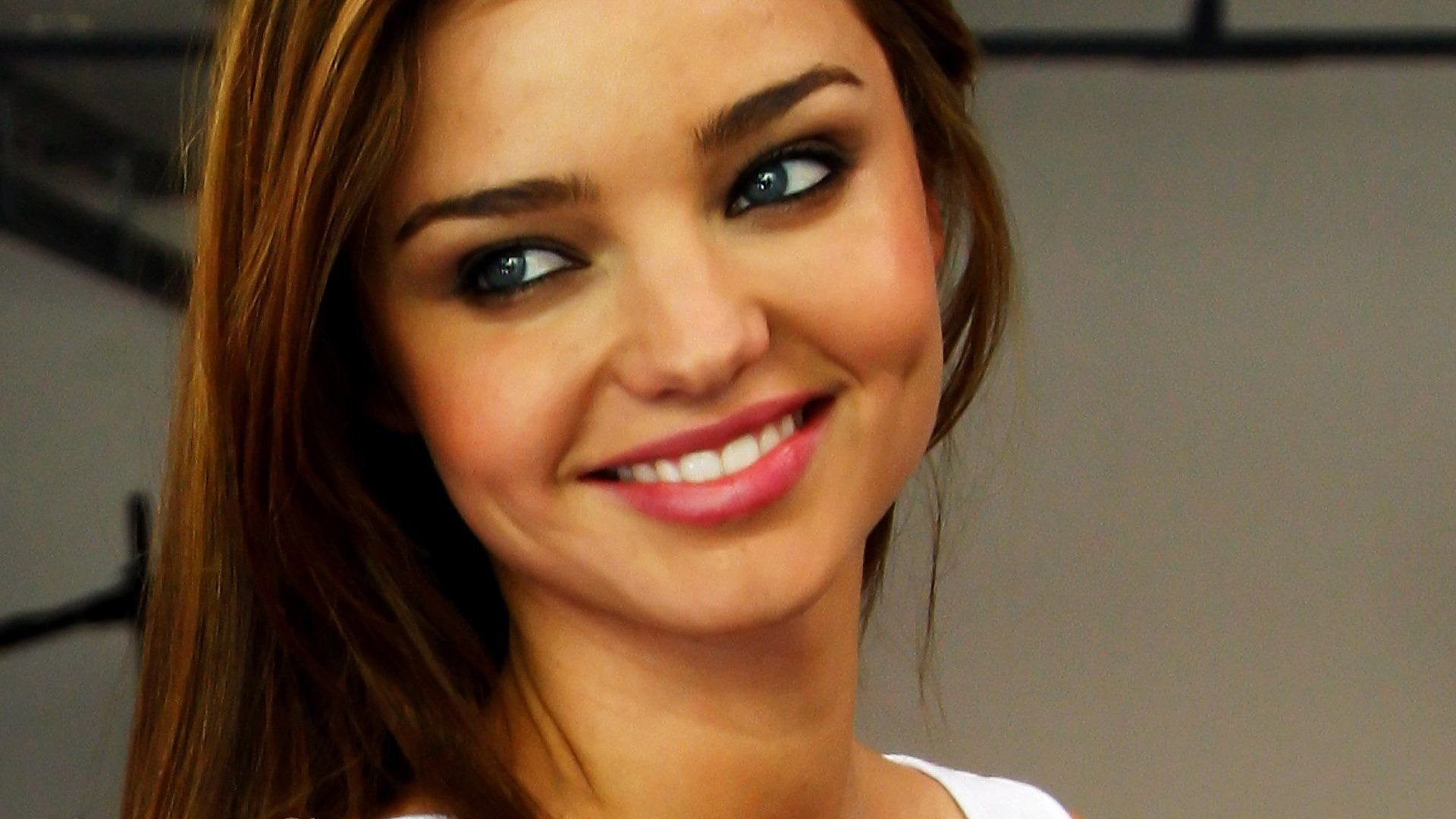 HD PC desktop wallpaper featuring a close-up of celebrity Miranda Kerr smiling with natural makeup and smooth hair.