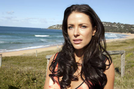 A stunning HD wallpaper featuring Ester Anderson as Charlie Buckton from the TV show Home and Away, with a scenic beach view in the background.