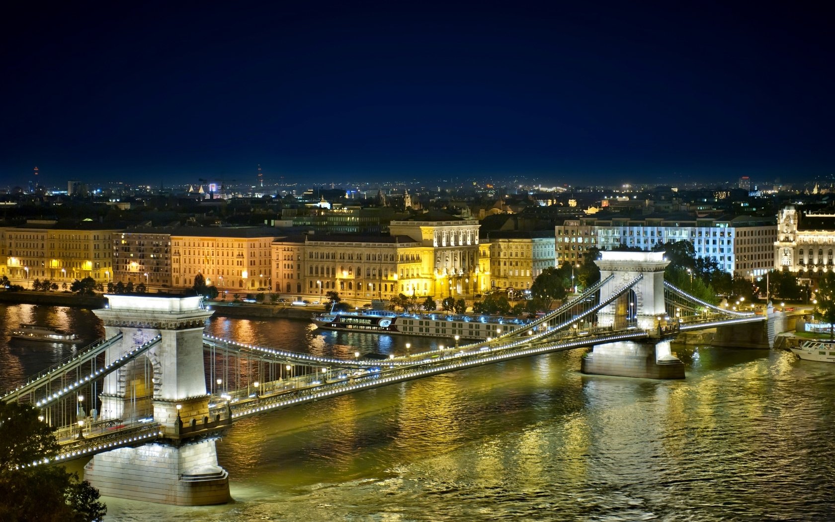 Night view of Budapest’s Chain Bridge spanning the Danube, illuminated and reflected in the water — a man-made landmark in Hungary, HD PC desktop wallpaper background.