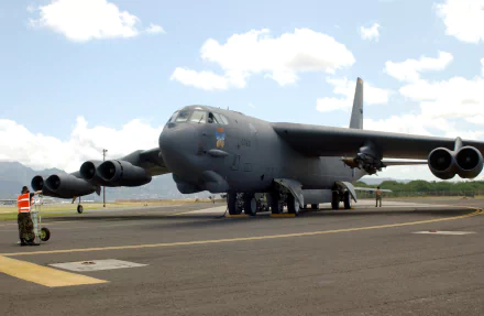 HD PC desktop wallpaper showing a Boeing B-52 Stratofortress military bomber on the runway under a partly cloudy sky.