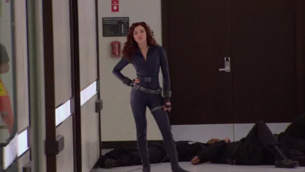 A scene from *Iron Man 2* featuring a confident female character in a sleek outfit, standing amid a dramatic backdrop with subdued lighting. An HD PC desktop wallpaper option.