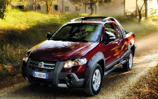 Red Fiat Strada vehicle parked on a sunlit country road — HD PC desktop wallpaper and background.