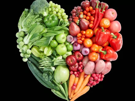 HD PC desktop wallpaper featuring a vibrant heart-shaped arrangement of fresh vegetables and fruits, showcasing green and red produce against a black background.