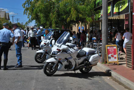 4K Ultra HD PC desktop wallpaper background of police vehicles — white police motorcycles parked on a sunny street with officers and a crowd nearby.