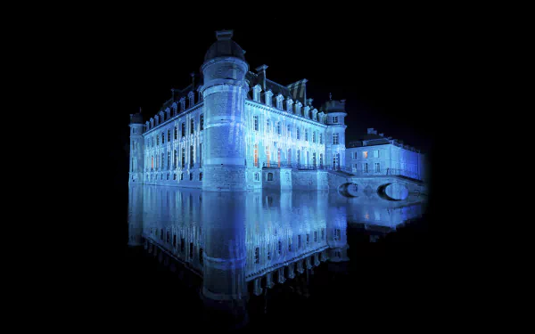 A stunning HD wallpaper featuring the illuminated Château de Beloeil, showcasing its elegant architecture reflected in the dark waters, creating a serene and captivating atmosphere.