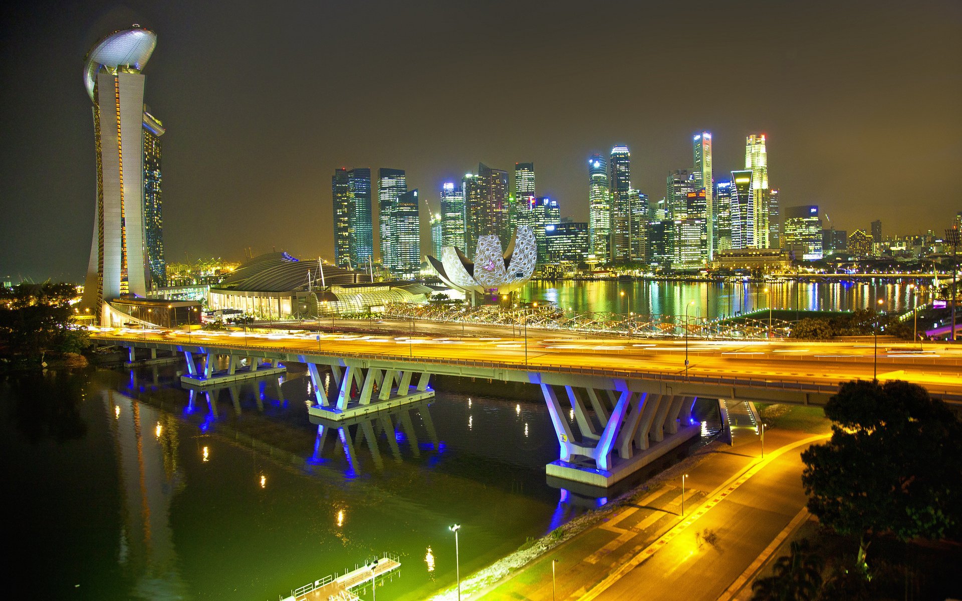 HD desktop wallpaper showcasing Singapore’s illuminated man-made skyline and iconic architecture at night, with reflections on the water.