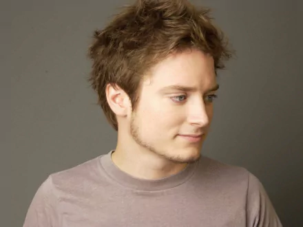 HD desktop wallpaper of a man with brown hair, looking to the side against a neutral background.