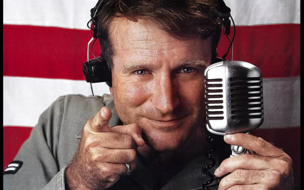 Man with headphones in front of an American flag, holding a microphone, as HD wallpaper for Good Morning Vietnam.