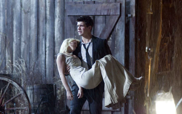 HD PC desktop wallpaper from the movie The Covenant (2006) featuring a man carrying a woman in front of a rustic wooden building at night.