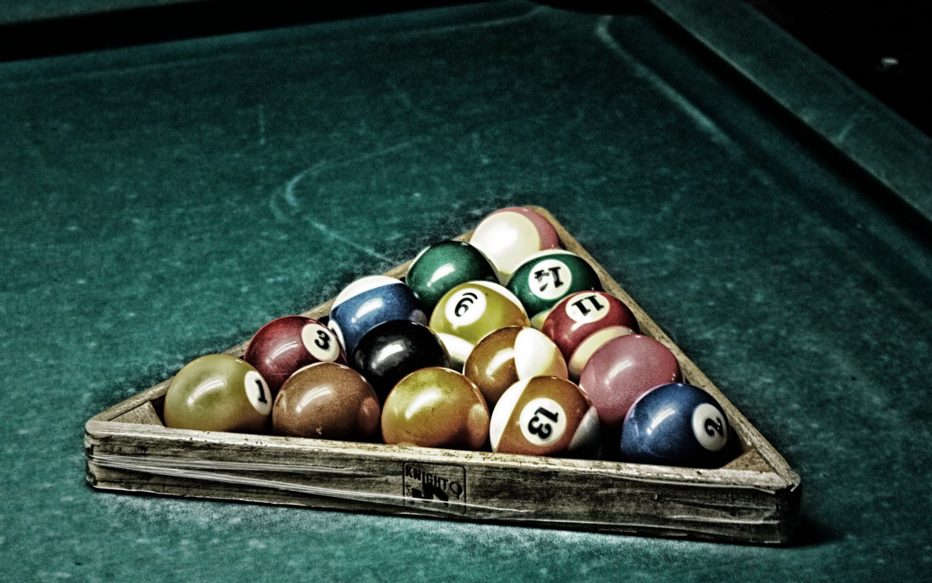 HD desktop wallpaper featuring a man-made pool game setup with colorful billiard balls neatly arranged in a triangular rack on a green felt table.