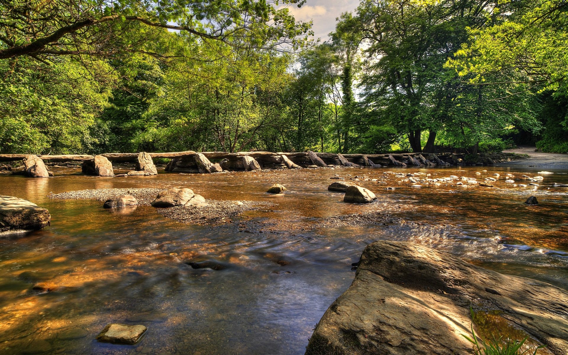2K Quad HD PC desktop wallpaper and background: sunlit river flowing over a stone weir through lush green forest — nature, river.