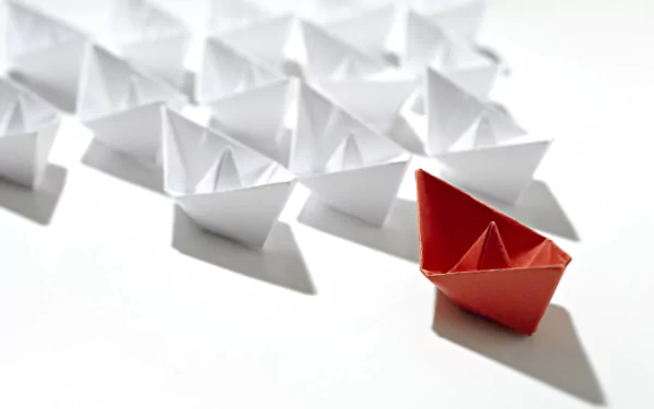 HD desktop wallpaper featuring man-made origami paper boats, with a standout red boat leading a group of white boats on a bright, minimalistic background.