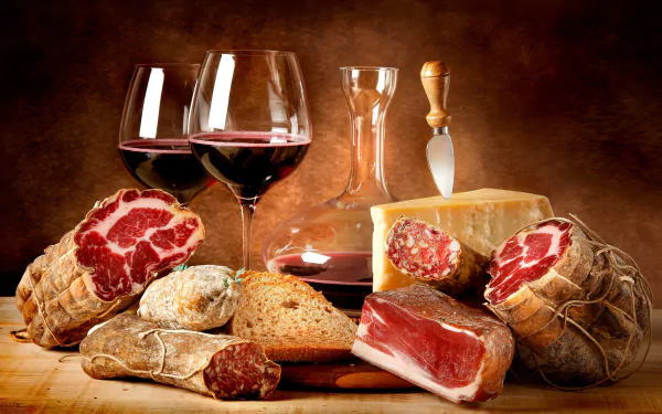 A 4K Ultra HD still life desktop wallpaper featuring assorted cured meats, bread, a wedge of cheese, and glasses of red wine on a wooden surface with a warm brown background.